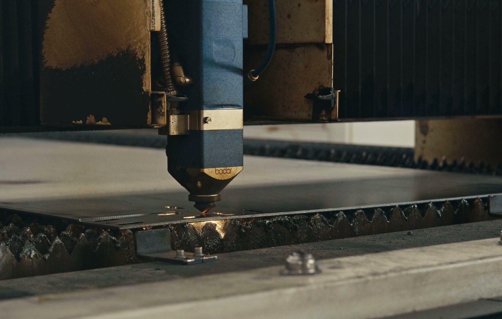 A laser cutting head at work on steel plate